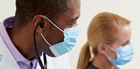 Detailní záběr klinického lékaře s fonendoskopem v uších
