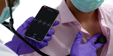 Klinický lékař používá digitální fonendoskop Littmann na hrudníku pacienta a prohlíží si živá data
