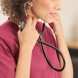 Zdravotní sestra vkládající do uší ušní olivky svého fonendoskopu 3M Littmann Classic III.